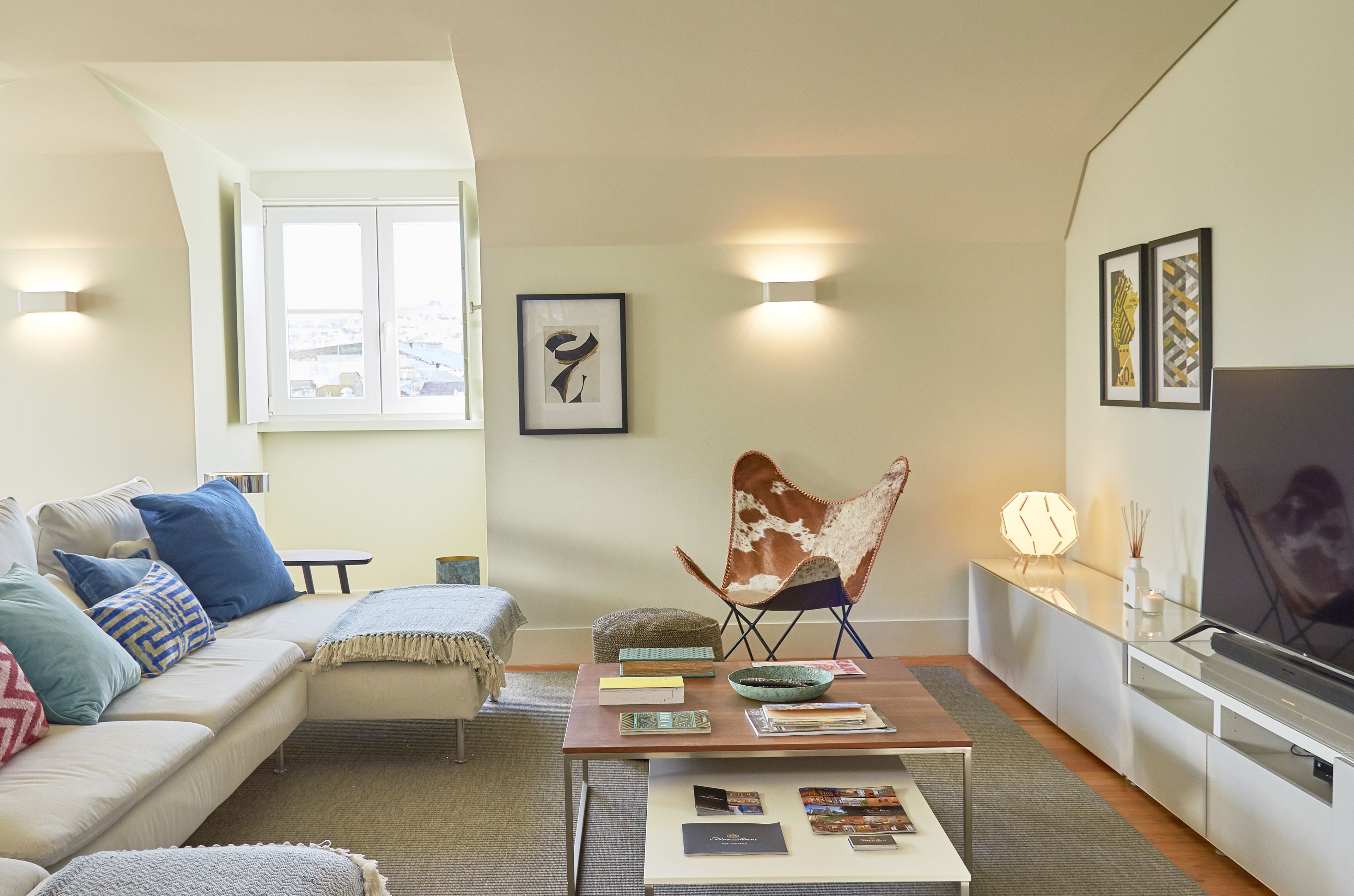 A modern living room with a sofa, coffee table, and a TV.