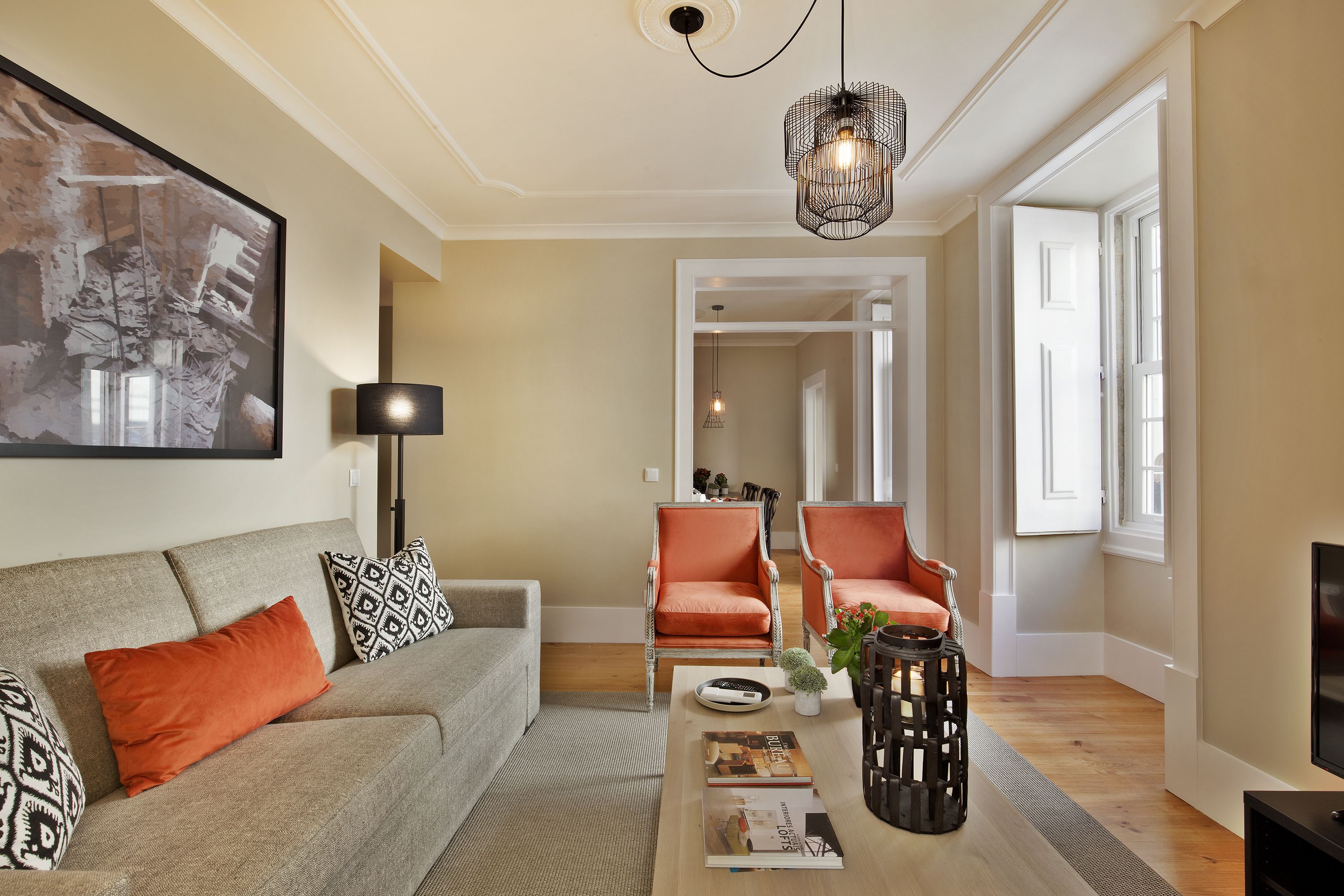 A living room with a sofa, two armchairs, a coffee table, and a bookshelf.