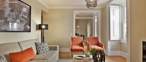 A living room with a sofa, two armchairs, a coffee table, and a bookshelf.