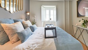 A bedroom with a bed, bedside table, and a mirror on the wall. - Lisbon Five Stars Apartments - Bica 246 (Lisbon)