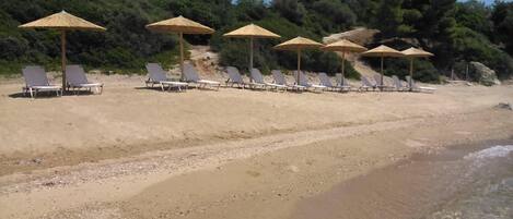 En la playa, camastros y sombrillas