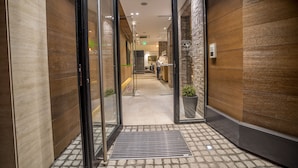A modern hotel entrance with a glass door, a metal threshold, and a tiled floor. - Hotel Belgrade Inn (Belgrade)