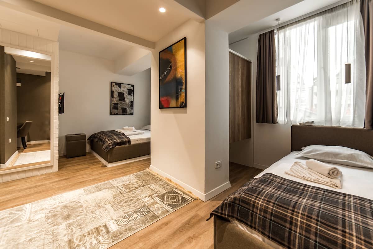 Ett modernt hotellrum med en stor säng, en soffa, ett litet bord och en tavla på väggen.