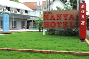 A hotel sign with the name "NANYA HOTEL" and a red pillar with Chinese characters.