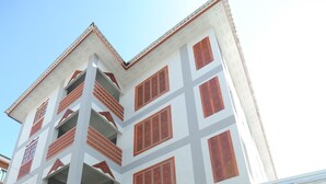 Un immeuble à plusieurs étages, doté d’un toit plat, de grandes fenêtres et d’un espace d’entrée abrité.