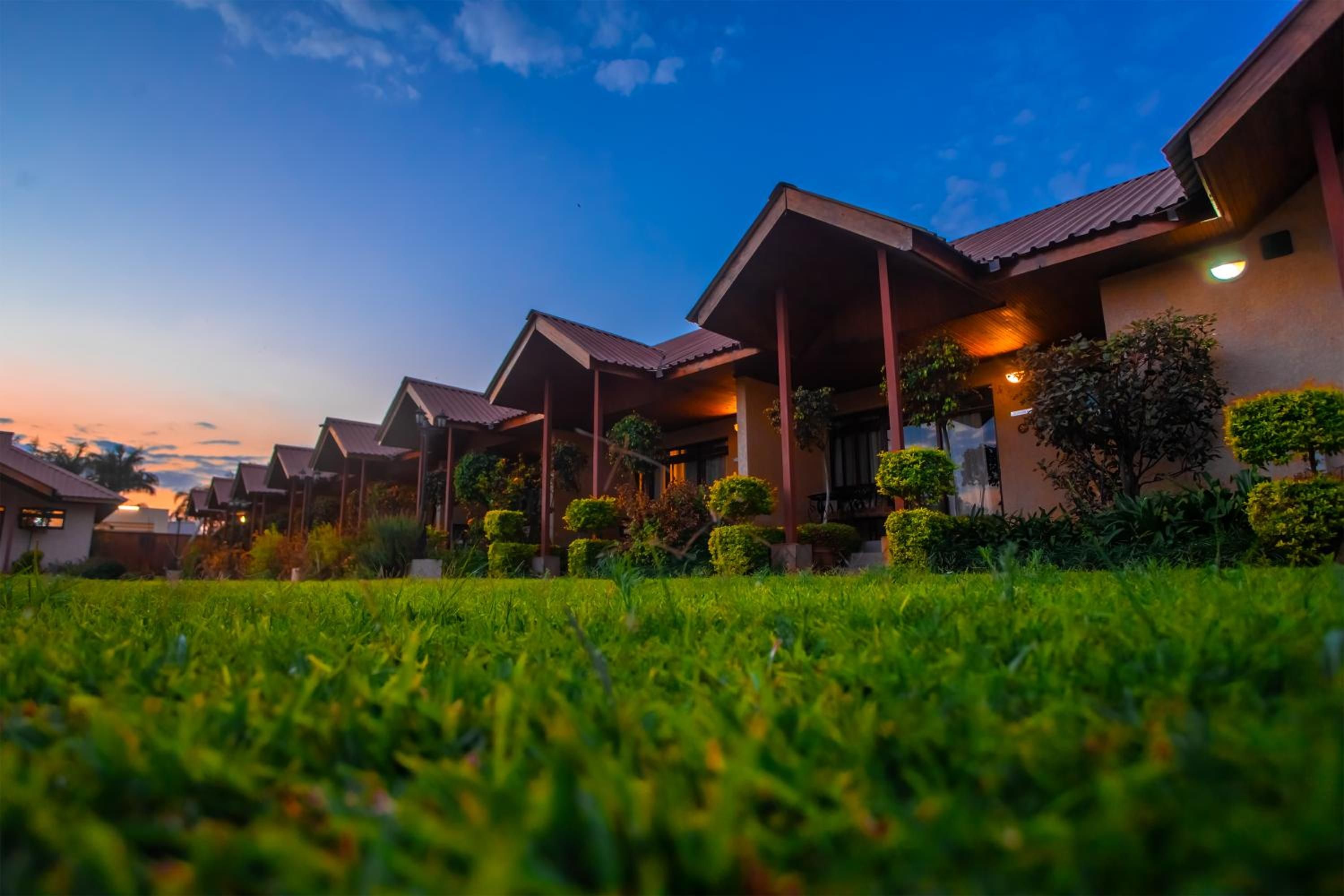A row of modern, single-story buildings with flat roofs and a well-maintained lawn in the foreground.
