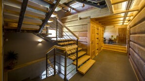 Un interno in legno con una scala, pareti in legno e un'area pranzo.