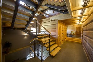 A wooden interior with a staircase, wooden walls, and a dining area.