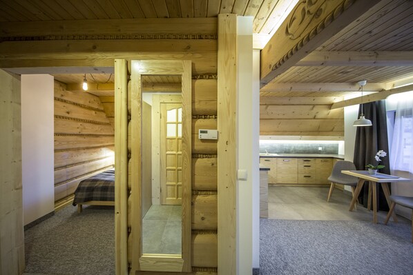 L'intérieur d'une cabane en bois comprend un lit, un coin cuisine et un espace repas.
