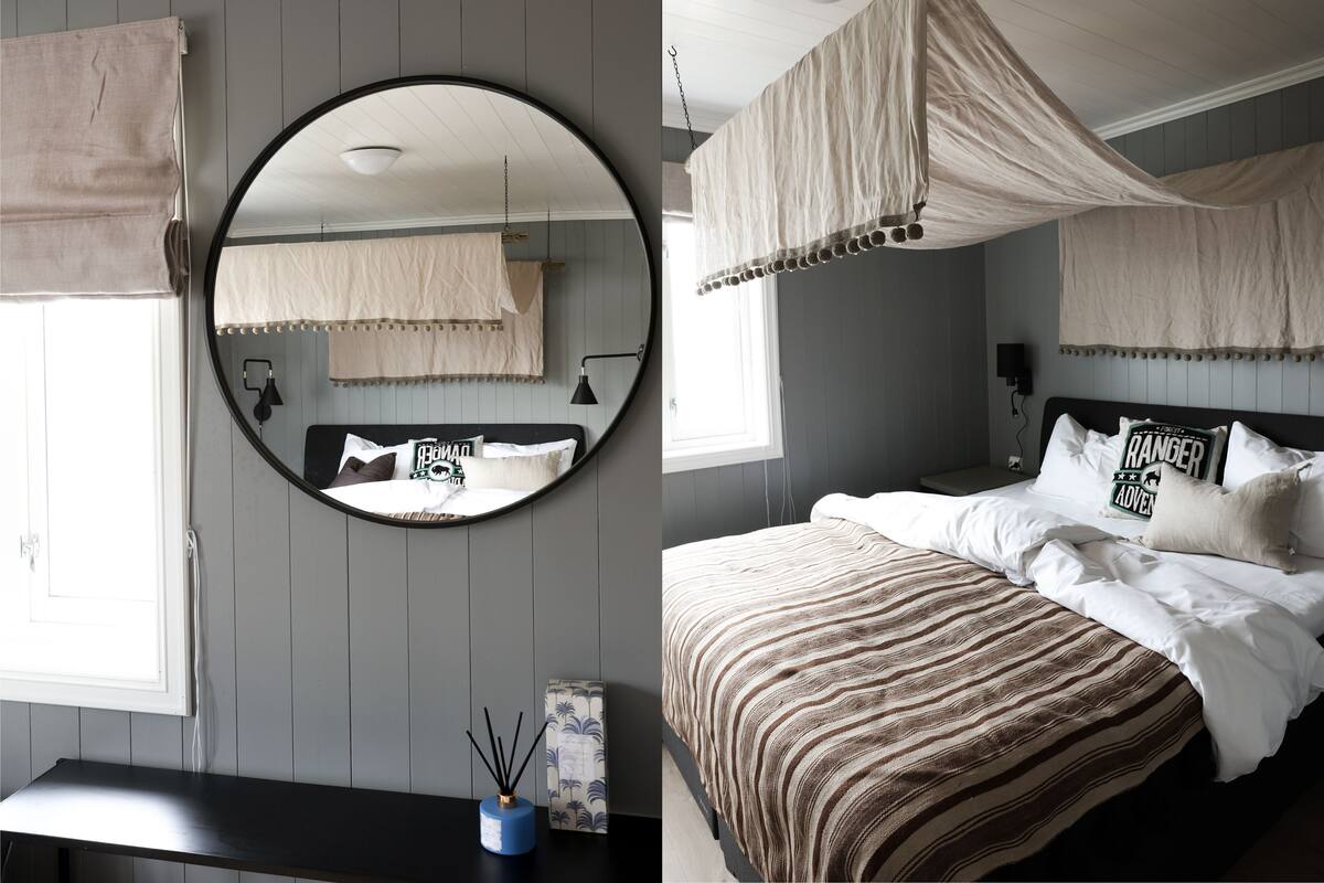 Une chambre à coucher avec un miroir rond, un lit avec une literie à rayures, une table de chevet et une petite table de nuit.