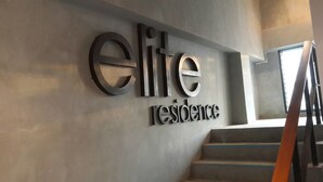 A sign for 'elite residence' with a modern design, located next to a staircase. - Elite Residence Phitsanulok (Phitsanulok)