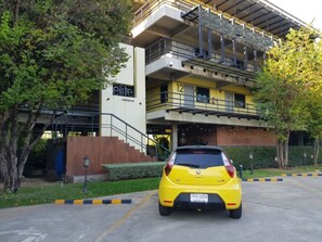 A yellow car parked in front of a building labeled 'elite residence' with a staircase leading to a second floor. - Elite Residence Phitsanulok (Phitsanulok)