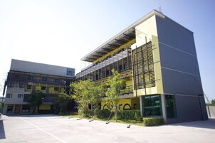 Un edificio moderno con techo plano, varios pisos y un amplio patio interior.