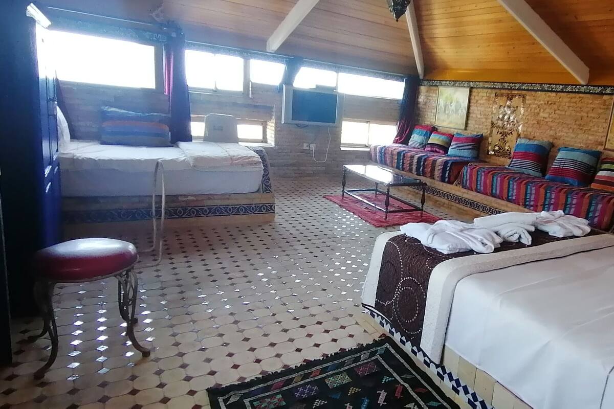 Una habitación acogedora con cama, sofá, una mesita y televisión.