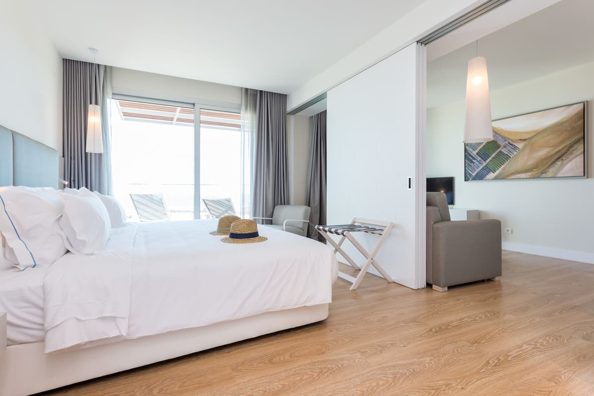 Una habitación de hotel moderna con una cama grande, un escritorio y una silla.