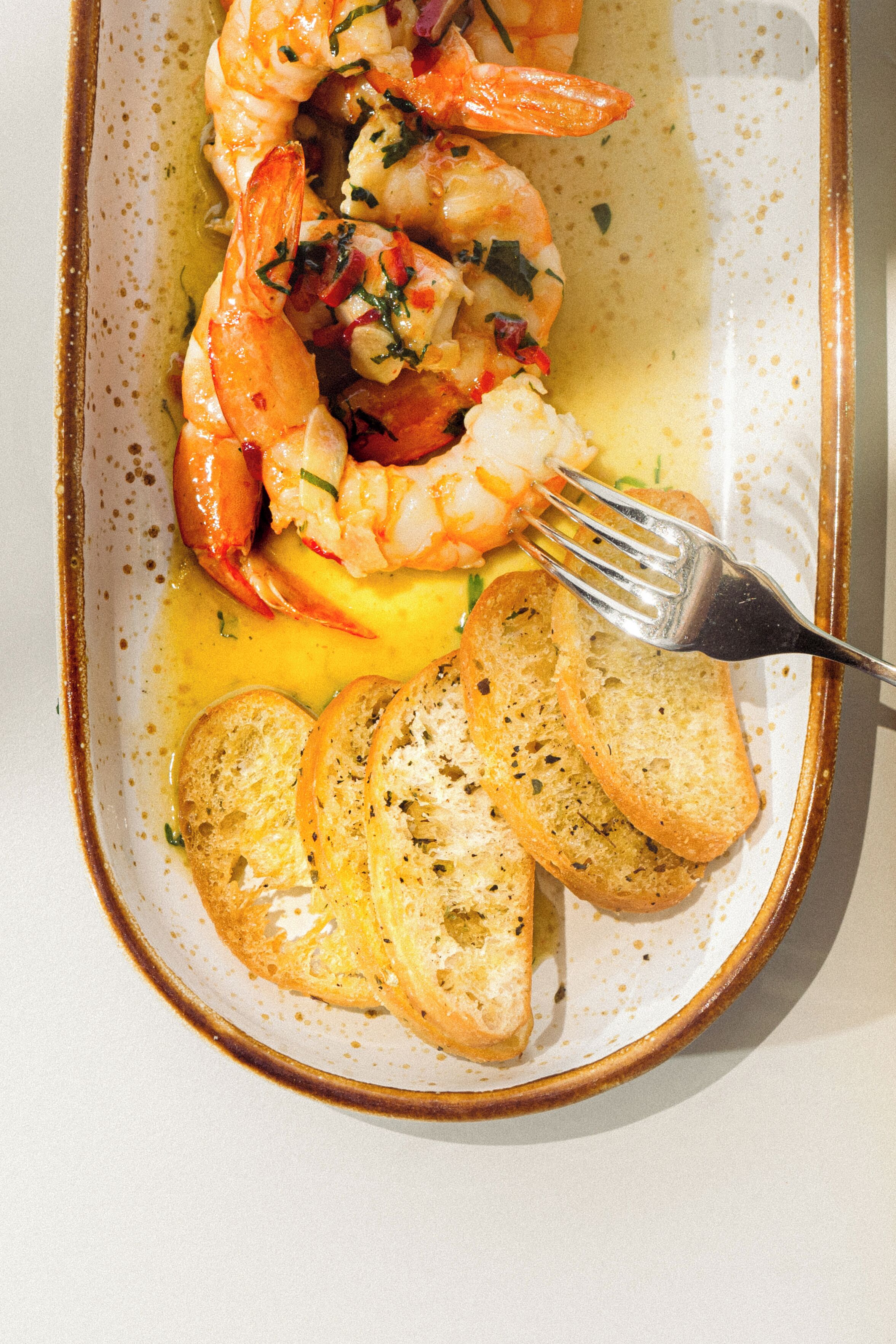 A plate of food with shrimp and bread.