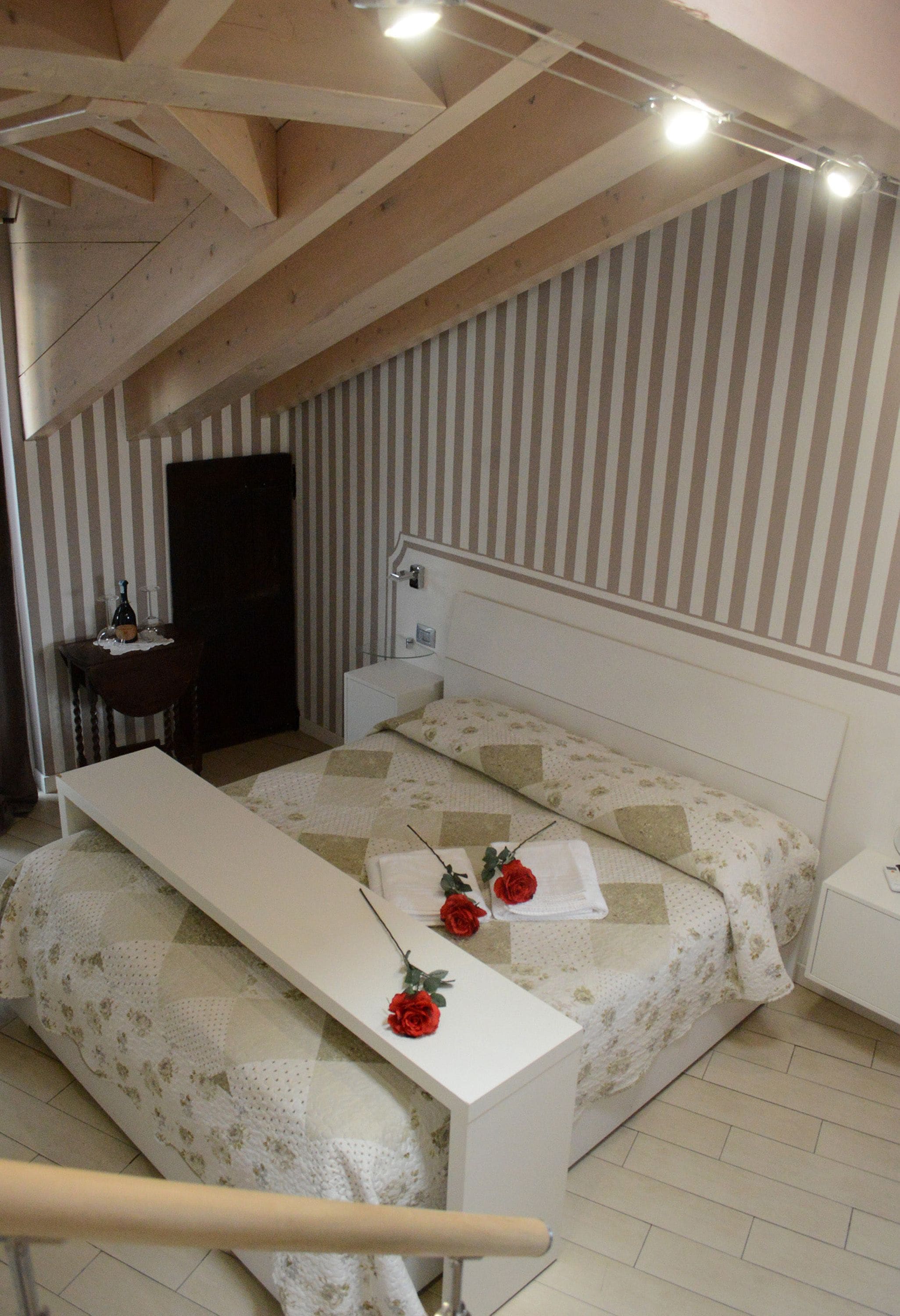 Ein Schlafzimmer mit einem Bett, einem Nachttisch, einem Schreibtisch und einem Sessel.
