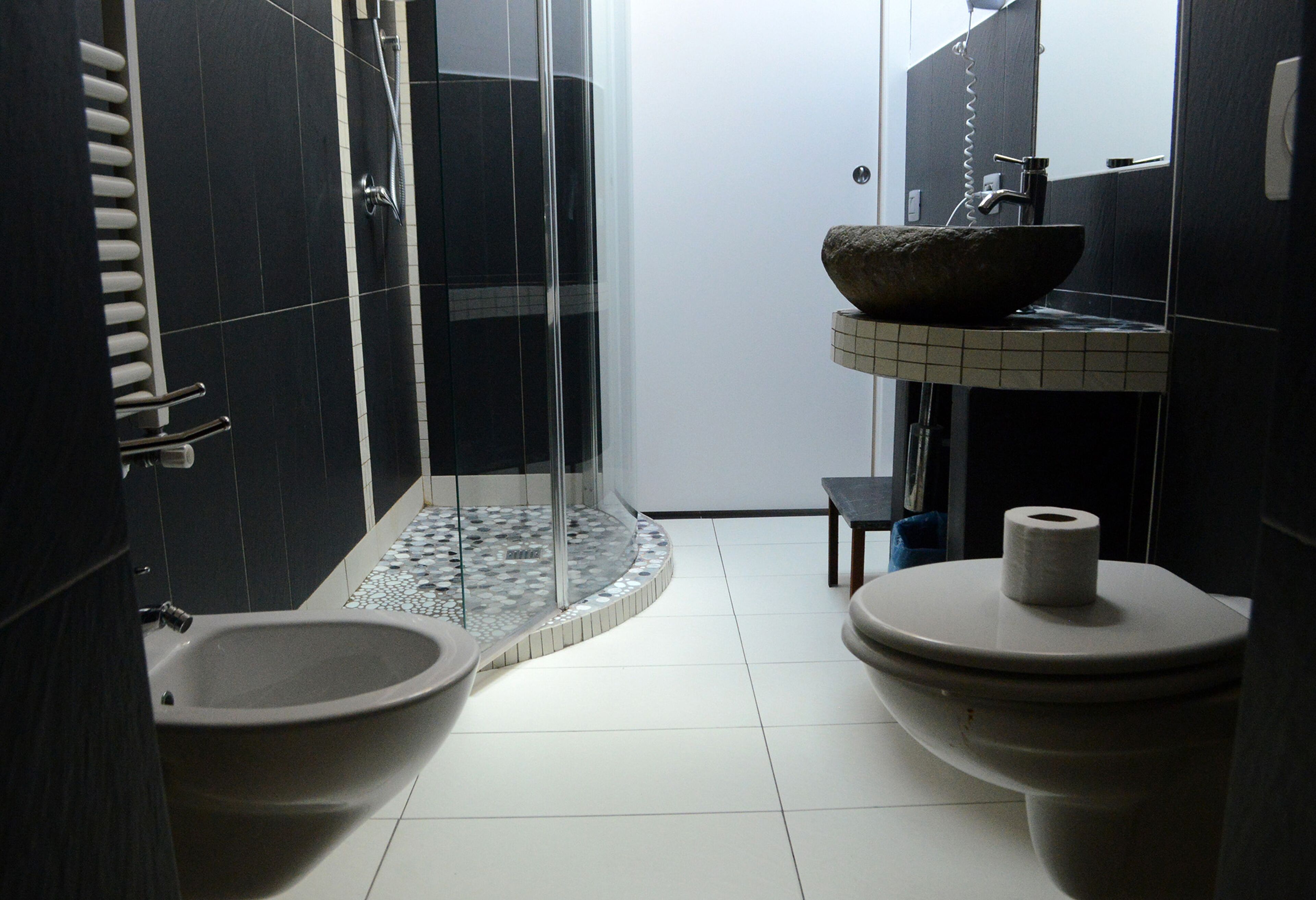 Ein Badezimmer mit Bidet, Toilette, Waschbecken und Dusche.