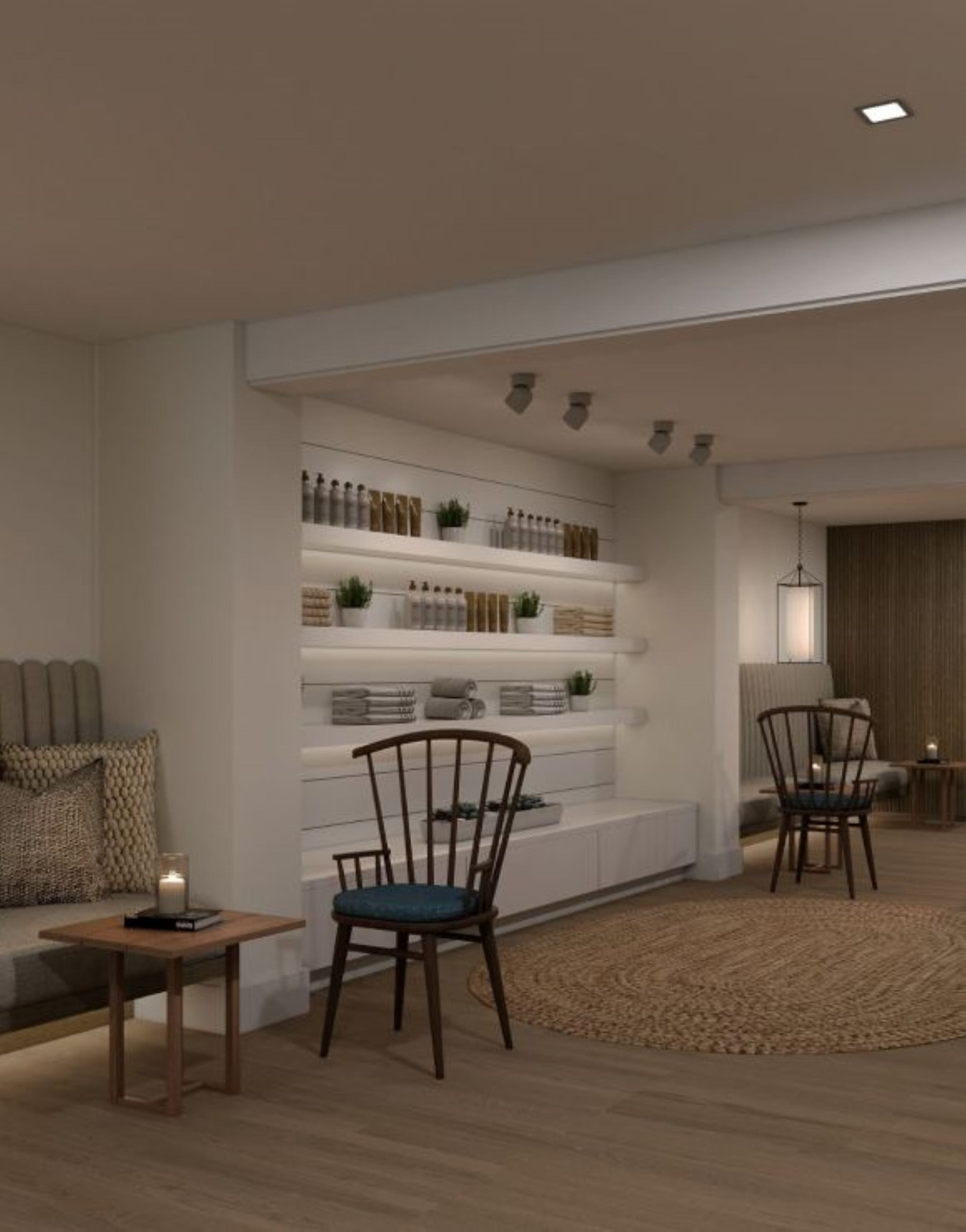 A modern living room with a built-in shelving unit, two wooden chairs, a small table with a candle, and a textured rug.