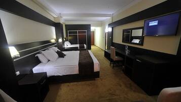 Una habitación de hotel con una cama grande, un escritorio, una silla, un televisor y un armario.