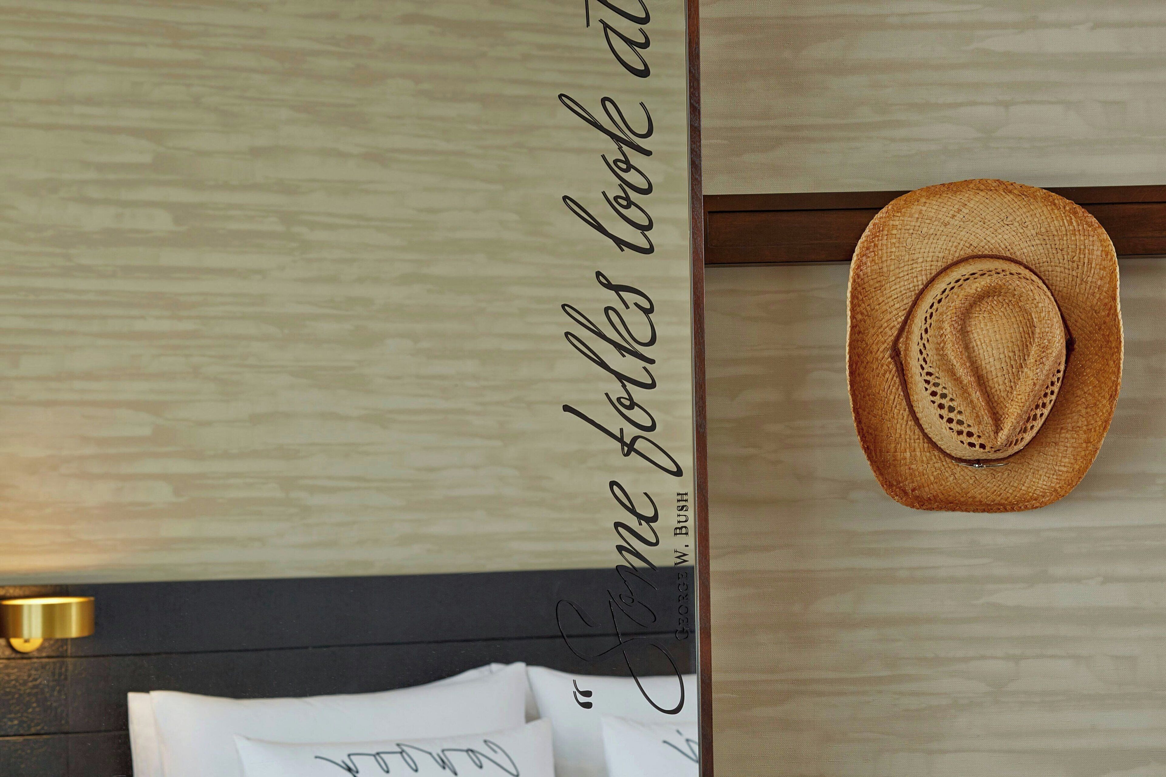 Una habitación con pared de madera, un sombrero y una pared con una cita.