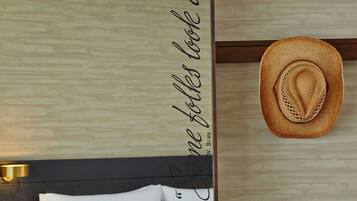 Una habitación con pared de madera, un sombrero y una pared con una cita.