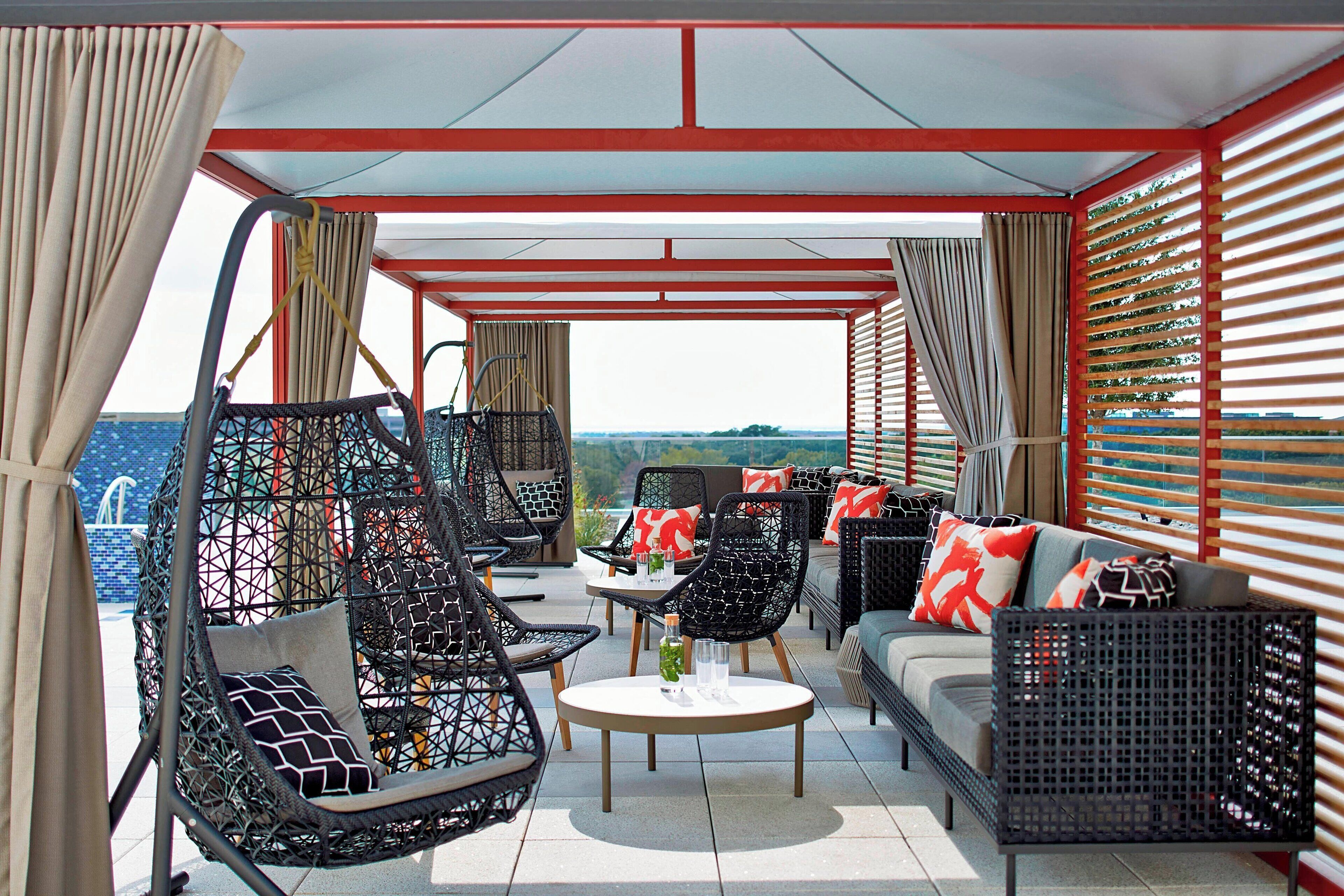 Un espace extérieur aménagé avec des meubles en osier, une table ronde et une vue sur la mer.