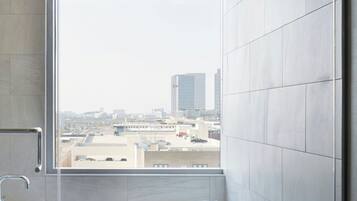 Ein modernes Badezimmer mit großem Fenster, einer Badewanne und einer Duschkabine.