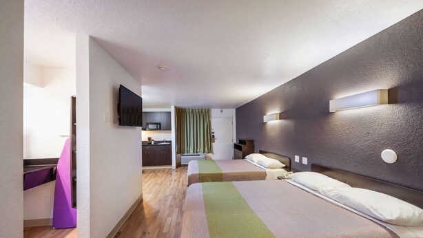 A modern hotel room with two beds, a kitchenette, and a bathroom. - Studio 6 Irving, TX - Irving DFW Airport East (Irving)
