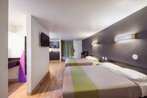 A modern hotel room with two beds, a kitchenette, and a bathroom. - Studio 6 Irving, TX - Irving DFW Airport East (Irving)