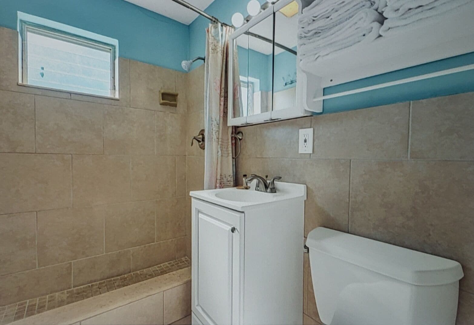 A bathroom with a shower, a sink, and a toilet.