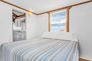 A bedroom with a bed, a window with blinds, and a view of the outside. - Old Wooden Bridge Resort and Marina (Big Pine Key)