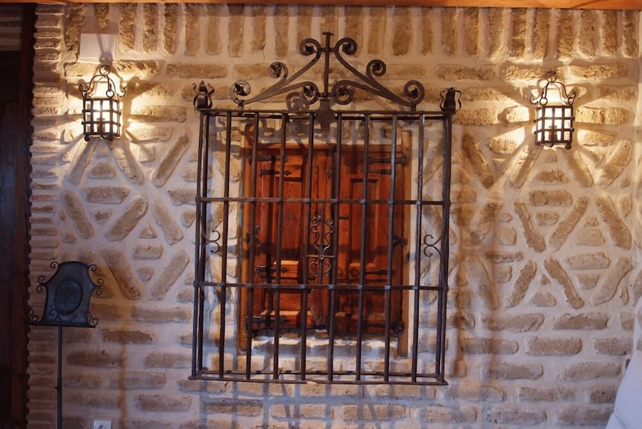 Detalle interior con muro de piedra y reja