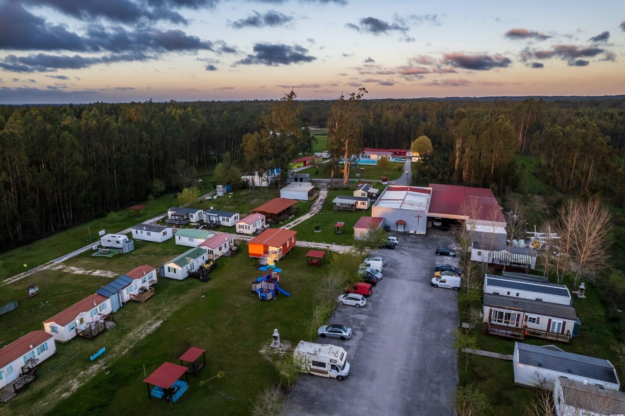 An aerial view of a campground with RVs, mobile homes, and a playground.
