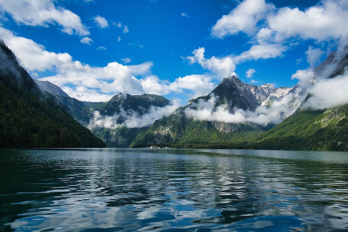 A serene lake surrounded by mountains with a clear sky.