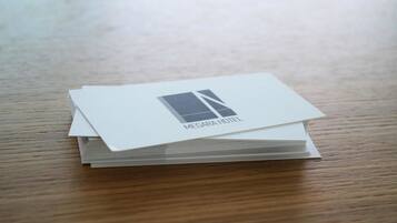 A stack of white business cards with the text "MEGARA HOTEL" on them, placed on a wooden surface.