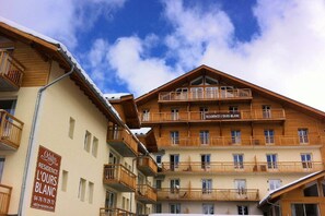 A multi-story hotel with balconies and a sign indicating 'RESIDENCE L'OURS BLANC'. - Apartment in French Alps for All Group Sizes (Les Deux Alpes)