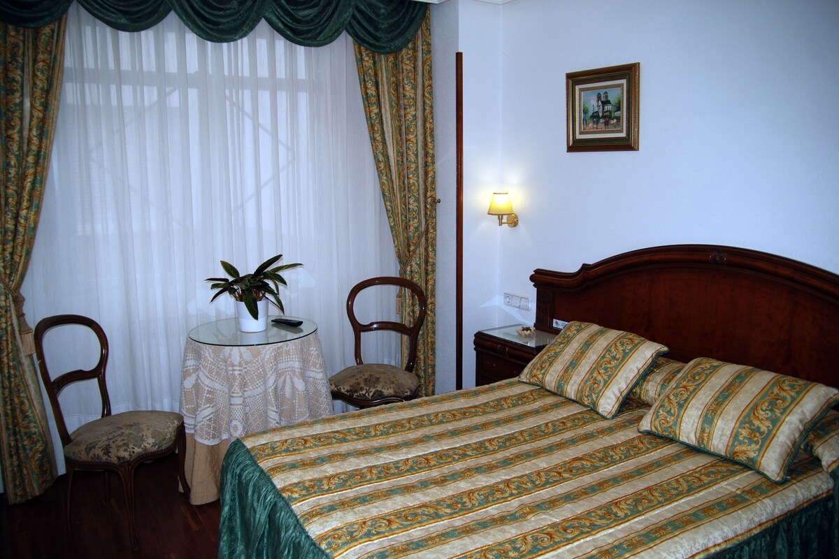 Minibar, escritorio, cortinas blackout y tabla de planchar con plancha 