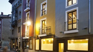A row of multi-story buildings with balconies and illuminated windows, suggesting a hotel or residential complex. - El Albergue de la Catedral - Hostel (Vitoria-Gasteiz)