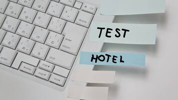 Un teclado con notas adhesivas que dicen 'TEST HOTEL'.