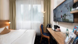 A hotel room with a bed, a desk with a chair, a TV, and a magazine rack. - EQC Hotel 776 (Osaka)