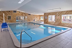 An indoor swimming pool with a wooden wall, a lifeguard chair, and a caution sign. - EQC Hotel 776 (Osaka)