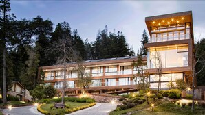 A modern hotel with a two-story structure, large windows, and a well-lit entrance.