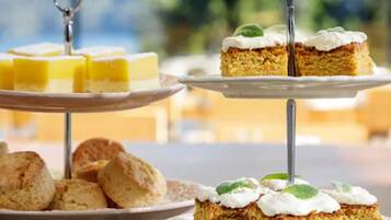A dessert display with cakes and scones on stands.