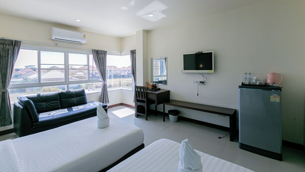 A hotel room with a bed, a sofa, a desk, a television, and a refrigerator. - Panwalee Hotel (Khon Kaen)