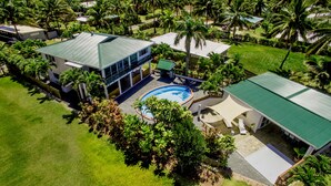 An aerial view of a resort with a swimming pool, multiple buildings, and lush greenery. - Whitehouse Apartments Rarotonga (Rarotonga)