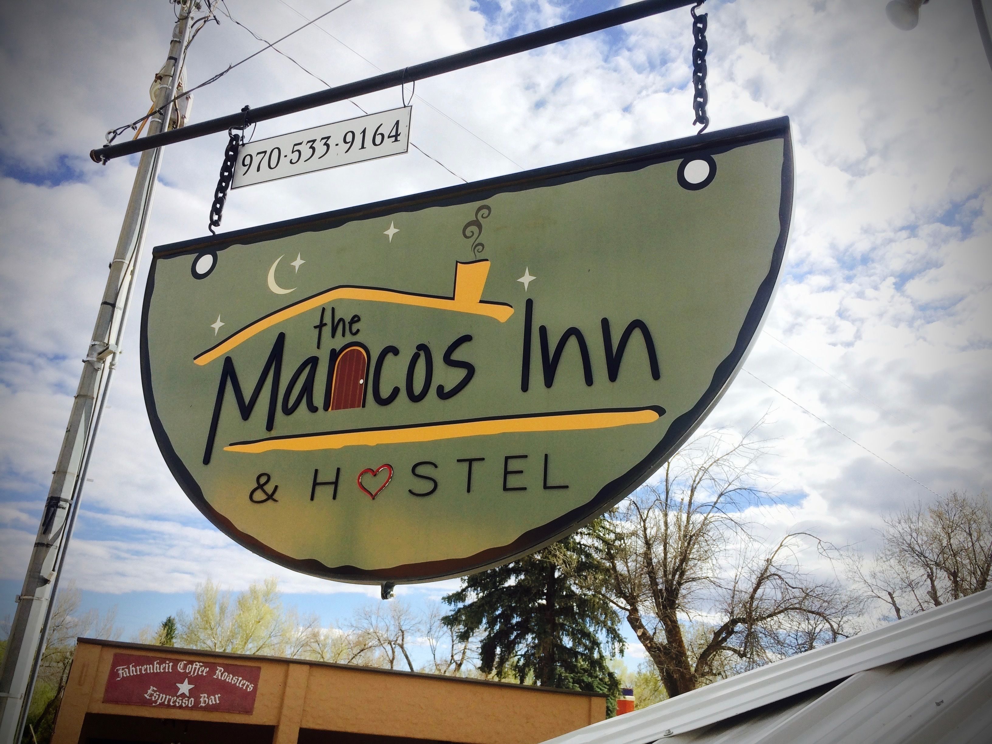 Een bord voor The Mancos Inn & Hostel met een contactnummer.