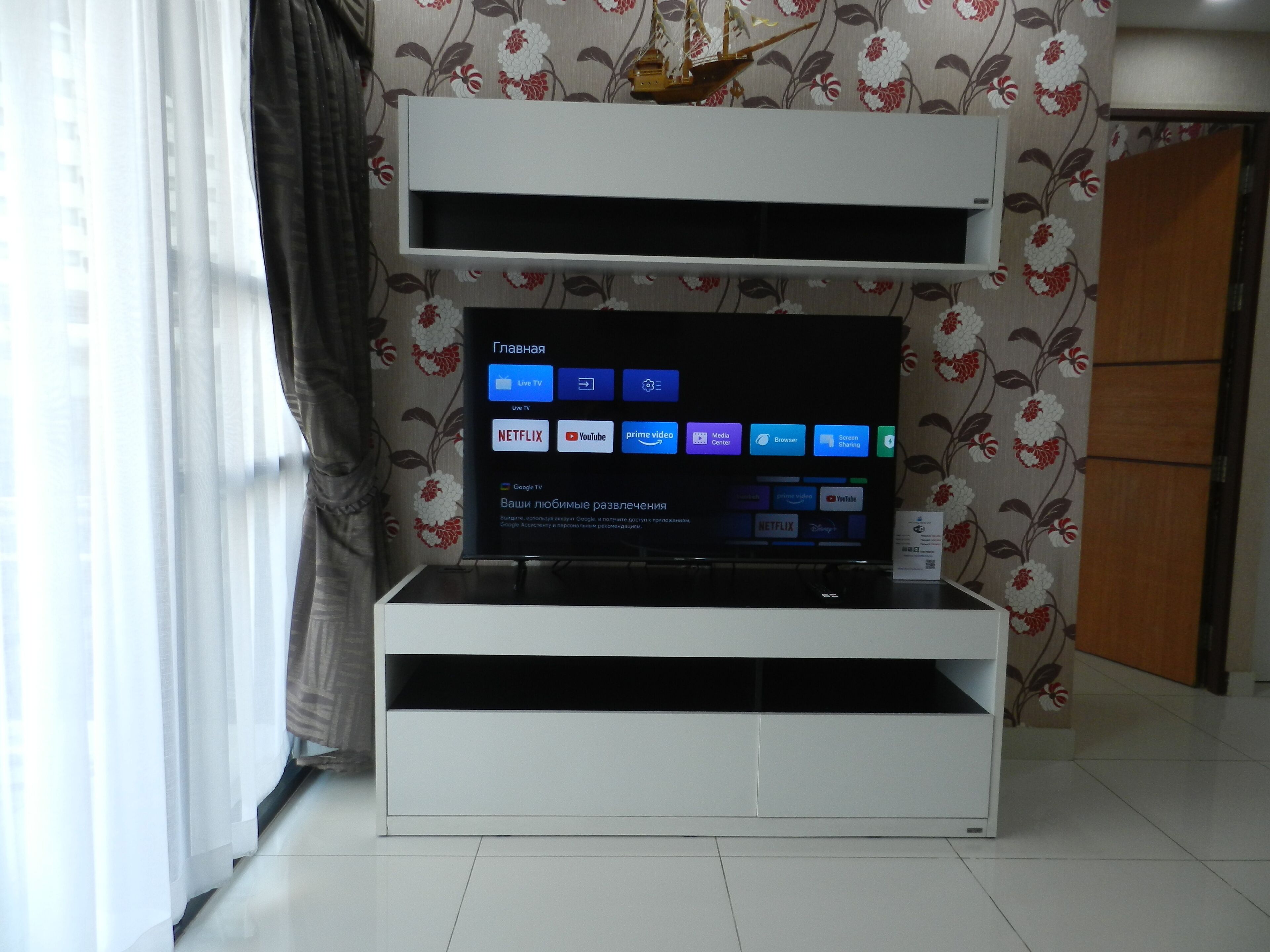 A modern entertainment unit with a flat-screen TV displaying various streaming services.