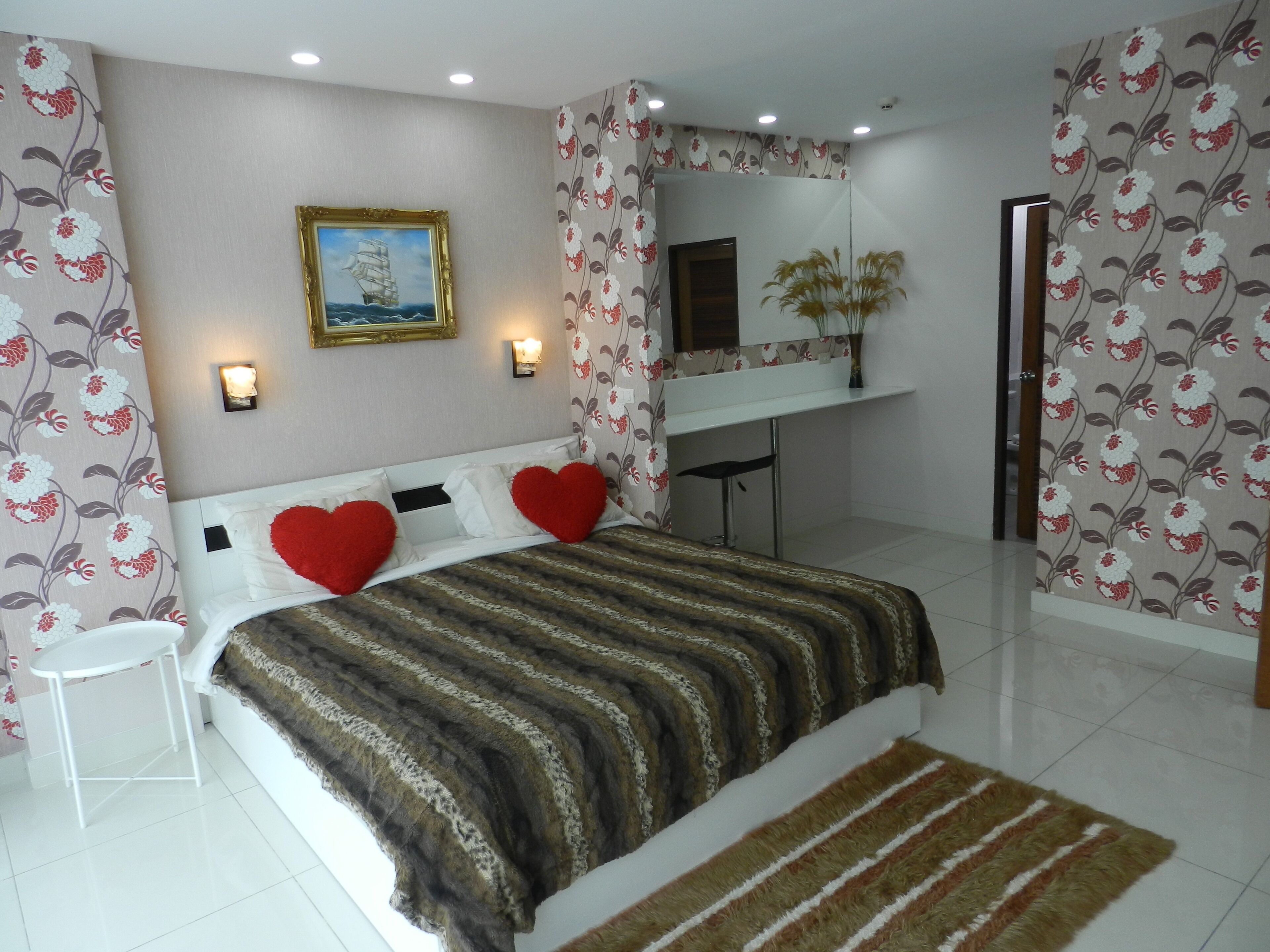 A modern bedroom with a bed, a desk, and a chair.