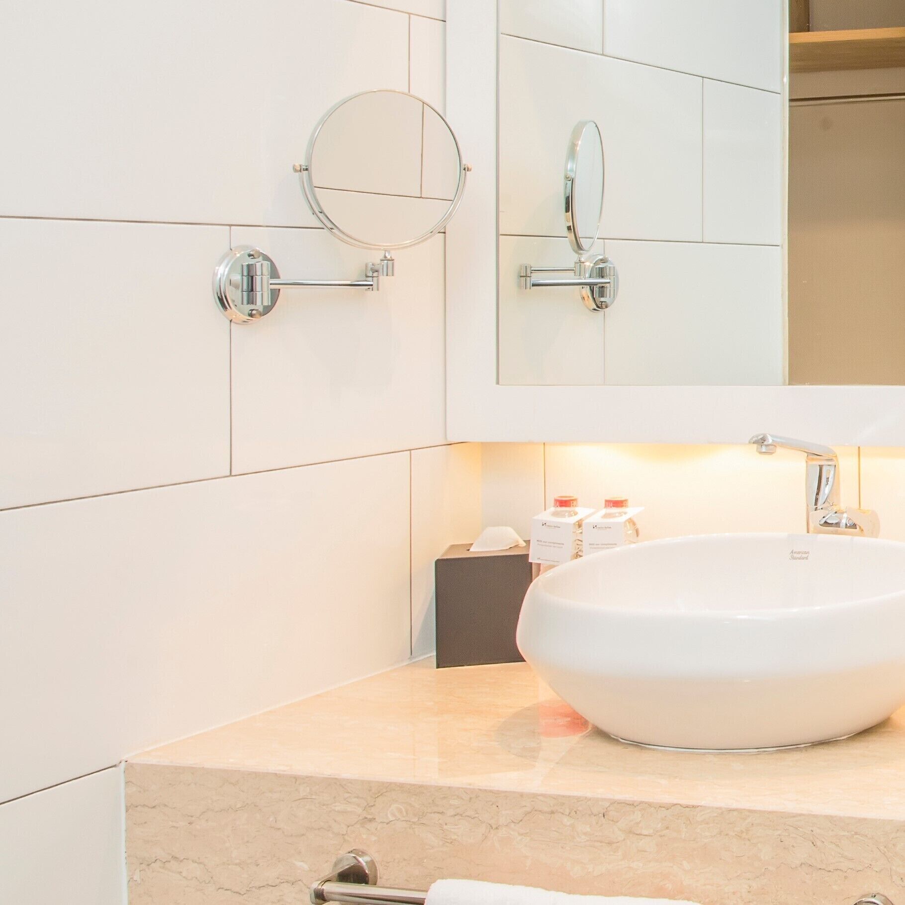 Une salle de bain moderne avec un grand lavabo ovale, un miroir rond et un robinet chromé.
